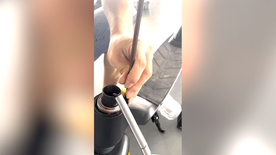 Zwei Hände, die die Lenkstange am Shift iQ E-Scooter mit Spezialwerkzeug anpassen.