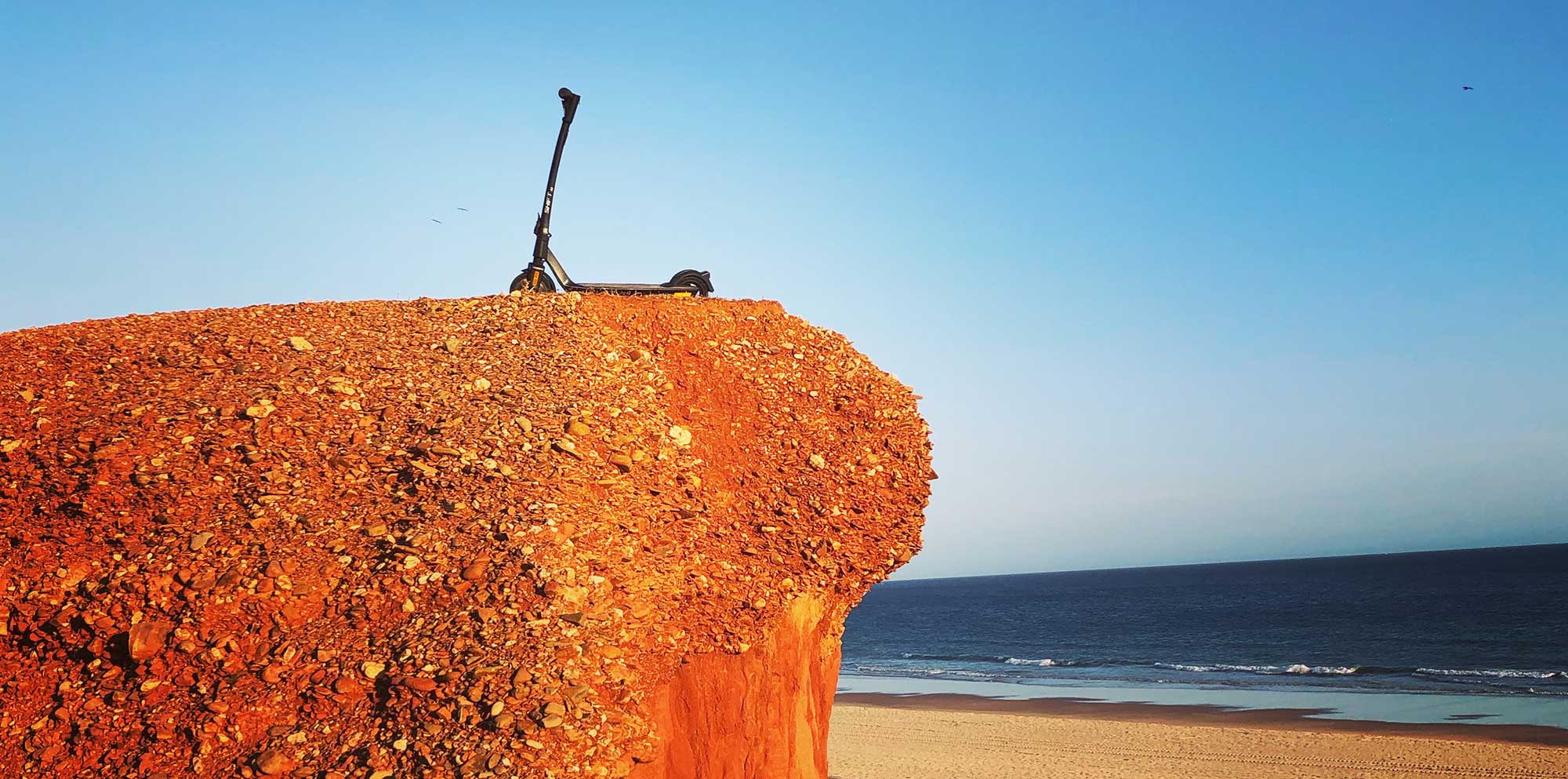 Shift iQ Escooter ohne Fahrer auf einer roten Klippe am Meer.
